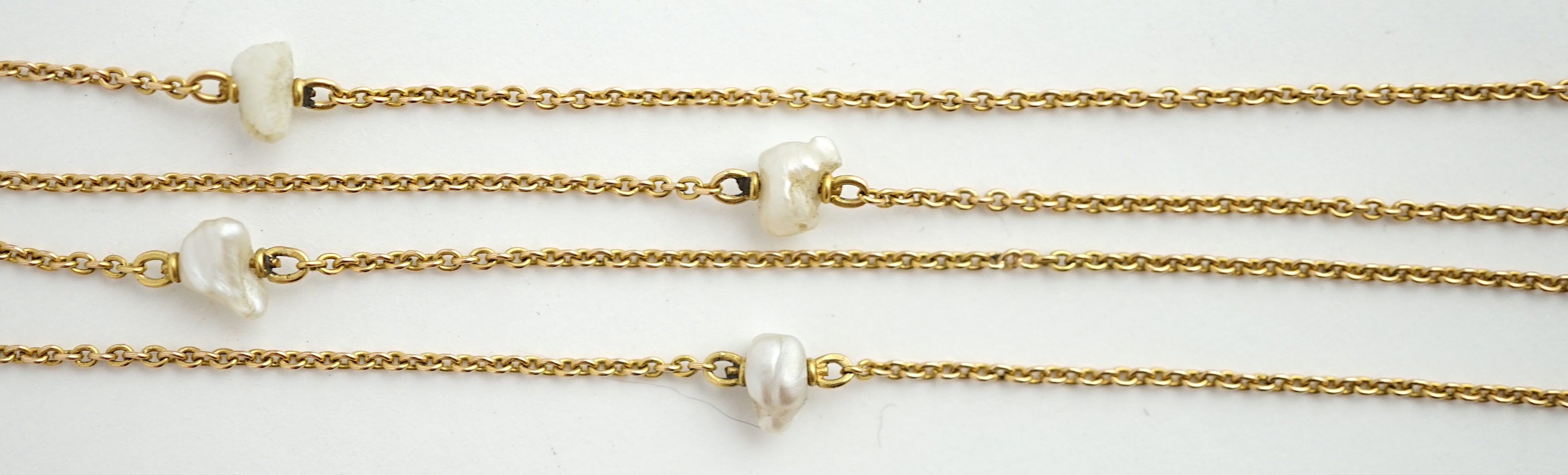 An early 20th century 15ct gold and ten stone baroque pearl set chain necklace